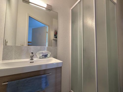 une salle de bain avec un lavabo et un miroir dans l'établissement T2 cabine avec climatisation et parking, 5 personnes à Sète - FR-1-472-208, à Sète