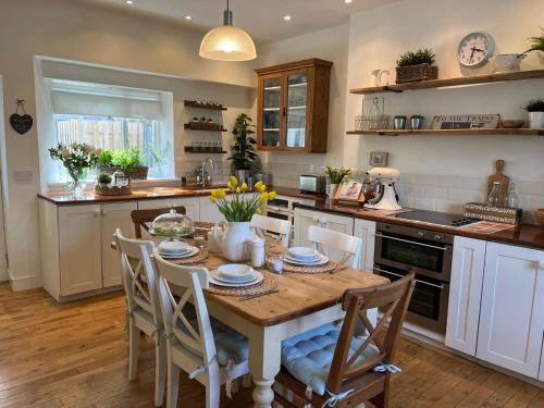 a kitchen with a table and chairs in a kitchen at Craigen Cottage Ballater in Ballater