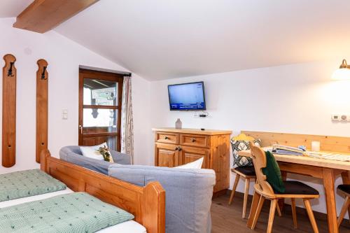 a living room with a couch and a desk at Hagerhof in Walchsee