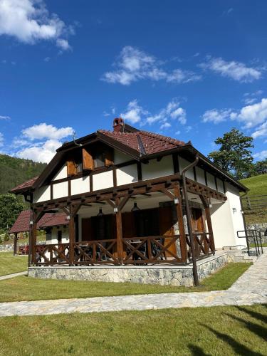 a building with a roof on a grass field at Uvački Eko Biser 
