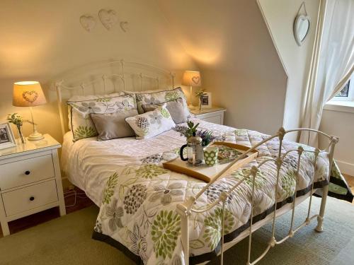 a bedroom with a bed with a white bedspread at Craigen Cottage Ballater in Ballater