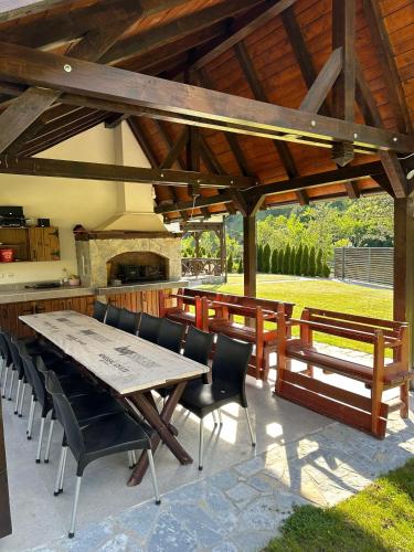 a patio with a table and chairs under a pavilion at Uvački Eko Biser 