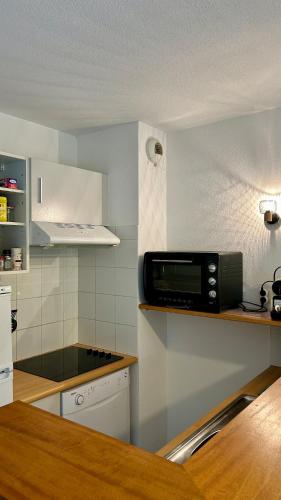 une cuisine avec un four micro-ondes assis sur un comptoir dans l'établissement Maison de vacances à 800m de la plage, à Soulac-sur-Mer