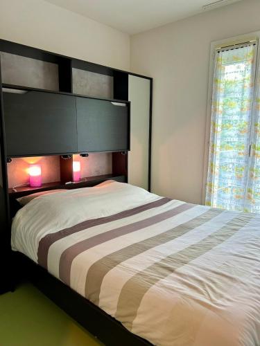 une chambre avec un grand lit avec des lumières dessus dans l'établissement Maison de vacances à 800m de la plage, à Soulac-sur-Mer