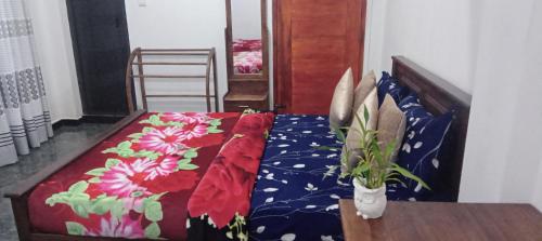a bedroom with a bed with a flower quilt at Vegetable Garden House in Adams Peak