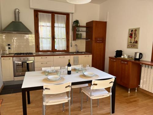 a kitchen with a table with chairs and a bottle of wine at I tre olivi in Montespertoli