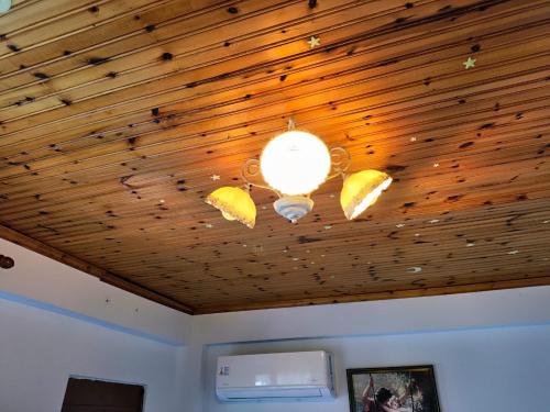 a room with a wooden ceiling with a light on it at Guri Guesthouse in Gjirokastër