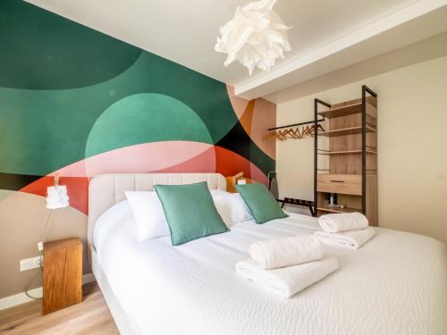 - une chambre avec un lit blanc et un mur coloré dans l'établissement OIQIA • Advena • Canson, à Annonay