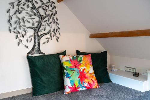 a room with two green pillows and a tree on the wall at Munnik's Hof in Amsterdam