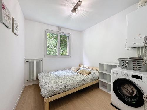 a white room with a bed and a washing machine at Vue Panoramique & Charme Romeuf E in Royat