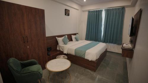 a hotel room with a bed and a chair at Hotel Aana Inn Prime Swiming Pool in Jaipur