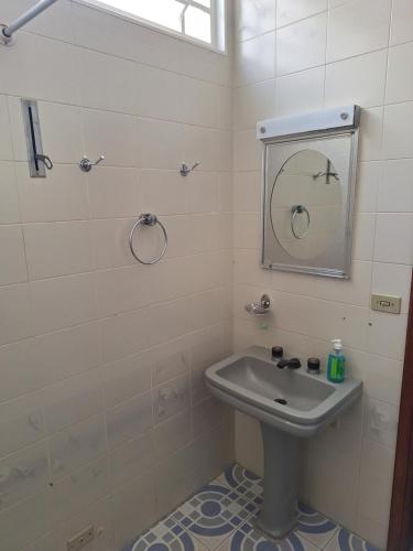 a bathroom with a sink and a mirror at Casa Assumpção, centro in Brotas