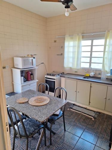 a kitchen with a table and chairs in it at Casa Assumpção, centro in Brotas