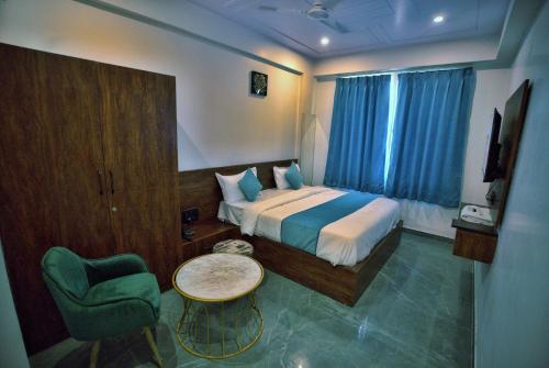 a hotel room with a bed and a chair at Hotel Aana Inn Prime Swiming Pool in Jaipur