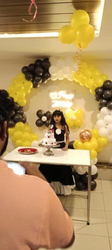 a woman standing in front of a table with a cake at Shree 9NB Hotels, Pithampur in Indore