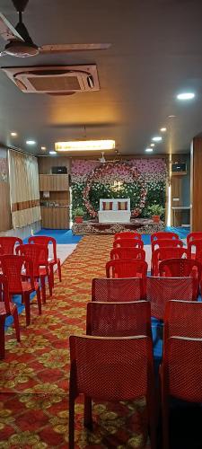 a room filled with red chairs and a stage at Shree 9NB Hotels, Pithampur in Indore