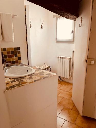 une salle de bain avec un lavabo et une baignoire dans l'établissement La Sarrasine, à Villes-sur-Auzon