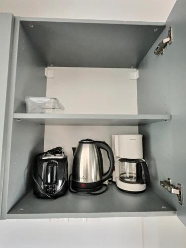 a shelf with two tea pots and a coffee maker at Appartement Cosy et Lumineux à Pommeuse - Proche Gare & studio de production idéal Couple et Professionelles in Pommeuse