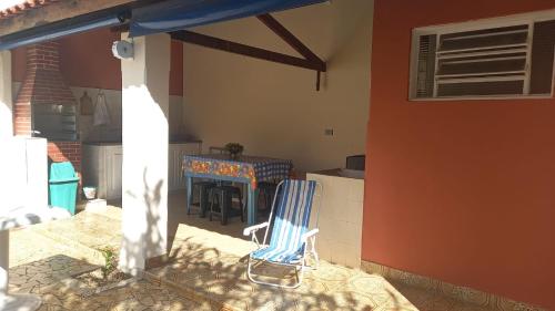 a blue chair sitting on a patio with a fireplace at Casa Assumpção, centro in Brotas