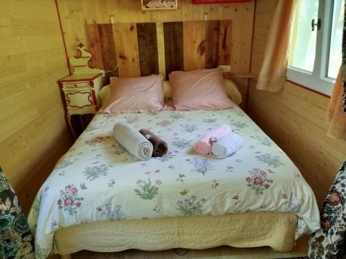 une chambre avec un lit avec deux serviettes dessus dans l'établissement Roulotte et Cabane Par Hasard, à Saint-Bressou