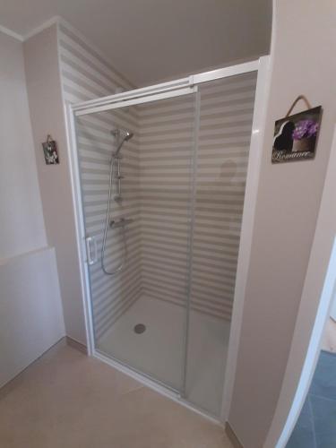 une douche avec une porte vitrée dans une salle de bain dans l'établissement Les Sables d'or, à Fréhel