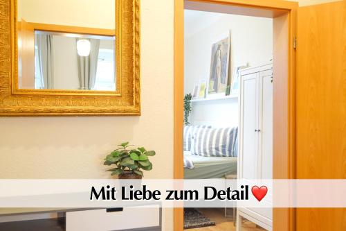 a mirror on a wall next to a living room at Großraum-Apartments mit 2SZ, WZ, Küche, Smart-TV, Parken, etc in Erfurt