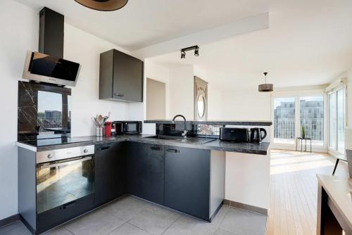 - une cuisine avec des comptoirs en noir et blanc dans l'établissement Spacious apartment with terrace - 4BR 8P - Pantin, à Pantin