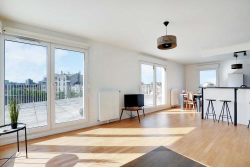 un salon vide avec une grande fenêtre dans l'établissement Spacious apartment with terrace - 4BR 8P - Pantin, à Pantin