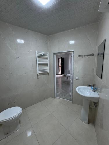 Un baño blanco con inodoro y lavabo. en House Nature Sea, en Makhinjauri