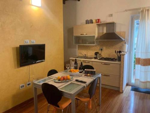 a kitchen with a table with a bowl of fruit on it at PiazzaItaliaSuite appartamento con terrazza in Cagliari