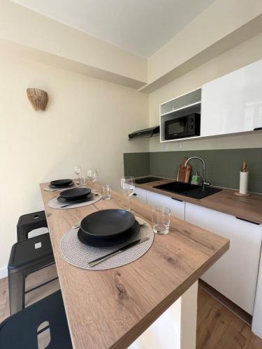 une cuisine avec une table avec des assiettes et des verres dessus dans l'établissement Studio au cœur d Amiens, à Amiens
