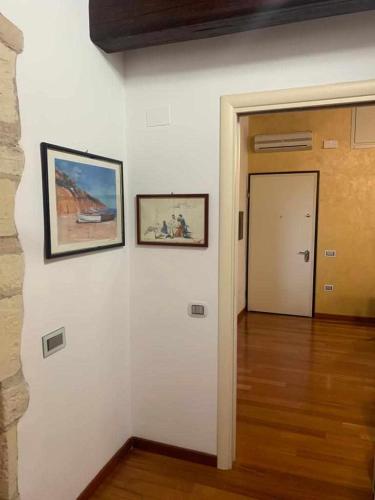 a hallway with two pictures on a white wall at PiazzaItaliaSuite appartamento con terrazza in Cagliari