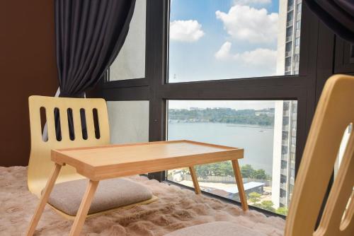 a table and a chair in front of a window at R&F Princess Cove by Nest Home at Johor Bahru in Johor Bahru