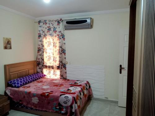 a bedroom with a bed with a curtain and a window at شاليه ديمورا عائلات فقط Dimora Chalet Only Family in Dawwār Muḩammad Abū Shunaynah