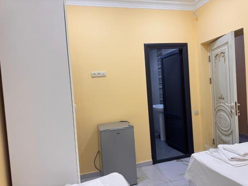 a bathroom with a toilet and a black door at Red Hotel Yerevan Center in Yerevan
