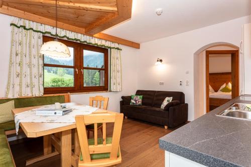 a kitchen and living room with a table and a couch at Hagerhof in Walchsee