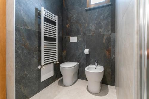 a bathroom with a toilet and a sink in it at Hotel Cristina in Rimini