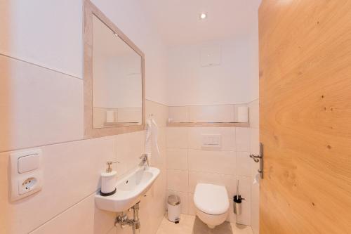 a bathroom with a sink and a toilet and a mirror at Hagerhof in Walchsee