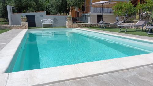 a swimming pool with blue water in a yard at Villa Leonardo in Canicattini Bagni