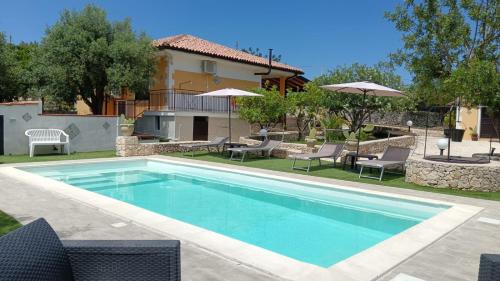 a swimming pool in front of a house at Villa Leonardo in Canicattini Bagni