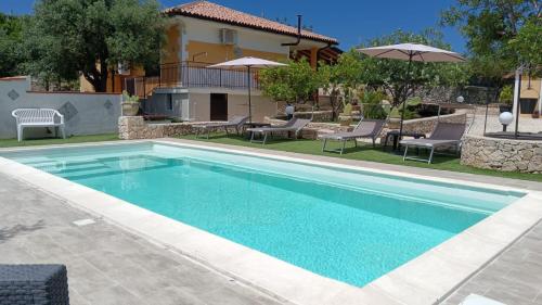 a swimming pool in front of a house at Villa Leonardo in Canicattini Bagni