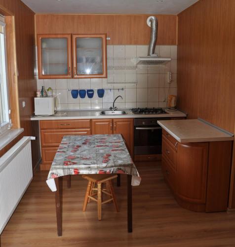 a kitchen with wooden cabinets and a table in it at Grodzisko11 in Skała