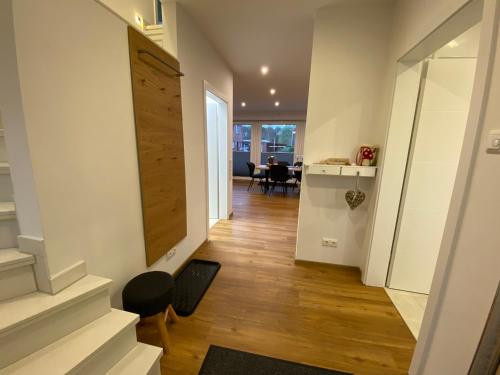 a hallway with a staircase and a living room at Luxus Ferienhaus Geest und Moor in Großheide