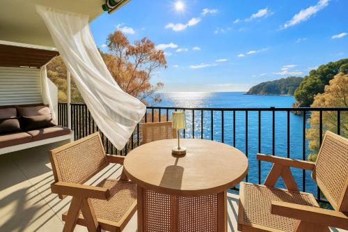 Un balcón con mesa y sillas y vista al agua. en Unparalleled sea view, en Tossa de Mar