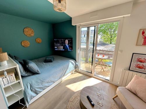 une chambre avec un lit et une porte coulissante en verre dans l'établissement Studio cosy la plage à pieds, à Bénodet