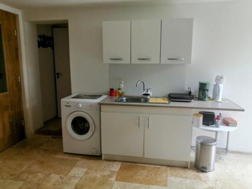 une cuisine avec une machine à laver et un évier dans l'établissement Chez Nathalie et flavien, à Meuilley