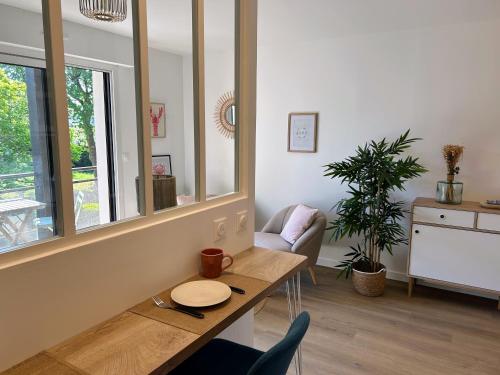 - un salon avec une table et un miroir dans l'établissement Studio cosy la plage à pieds, à Bénodet