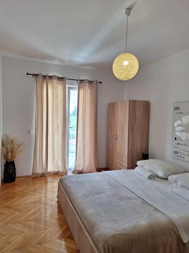 a bedroom with a large bed and a large window at House Roca in Vodice