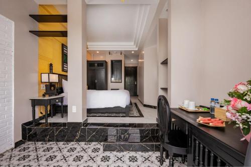 a hotel room with a bed and a desk at Old Town Hotel in Hoi An