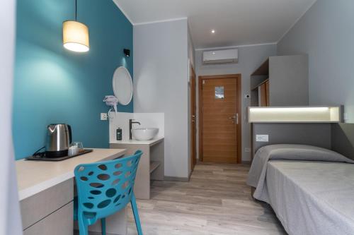 a bedroom with a bed and a blue wall at Hotel Cristina in Rimini